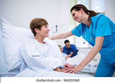 Nurse Consoling A Patient In Ward At Hospital