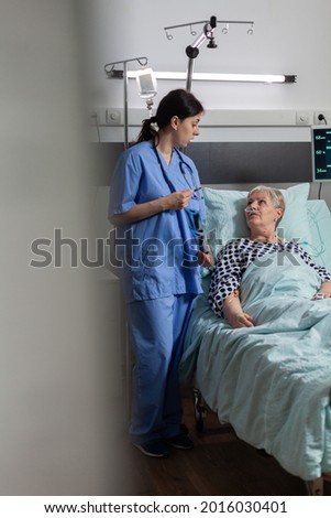 Similar – Caregiver helping elderly female patient to get out of bed