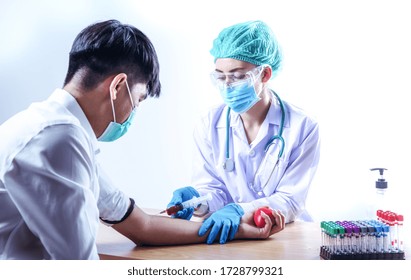 Nurse desinfizieren männlichen Arm vor dem Bluttest. Der Mensch sitzt auf einem Stuhl in der Nähe des medizinischen Sets