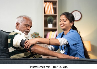 Nurse Of Doctor Busy In Setting Up BP Or Blood Pressure Medical Equipment To Senior Man At Home Of Check Up At Home - Concept Of Routine Home Help Check