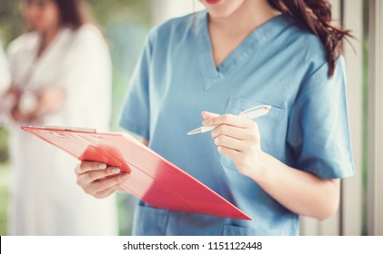 Nurse or doctor holding a medical chart , blurred background of Medical team discussing and working together, Medical education, health care,  Medical conferrence concept.