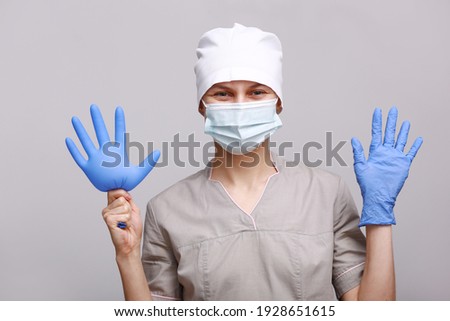 Nurse or doctor holding or putting on blue gloves isolated on white background