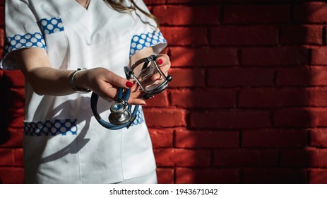 Nurse Or Doctor Holding A Stethoscope (shallow Depth Of Field), Selective Focus, On A Black Background, Low Key.