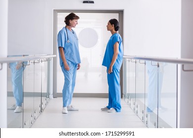 Krankenpflege und Arzt, die im Krankenhauskorridor miteinander interagieren