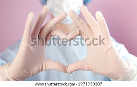 Nurse or doctor in in medical gloves shows the symbol of the heart. Doctor care and love concept to patients. Love, care and safety symbol. Close-up.