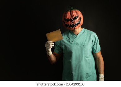 Nurse Doctor, Wearing A Halloween Mask, Holding A Sign With Copy Space, In Front A Black Background.