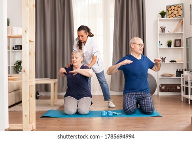 Nurse Doing Physical Therapy With Senior Couple. Home Assistance, Physiotherapy, Healthy Lifestyle For Old Person, Training And Healthy Lifestyle