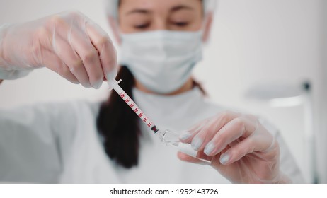 Nurse draws the vaccine into the syringe and prepares for the vaccination. A young nurse in a medical institution is vaccinated against coronavirus, influenza, and other diseases.