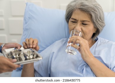 Nurse, Elderly Woman And Take Medicine. Elderly Asian Woman Taking Medicine And Drinking Water On Bed At Hospital