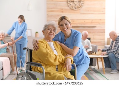 Nurse with elderly woman in wheelchair at retirement home. Assisting senior people