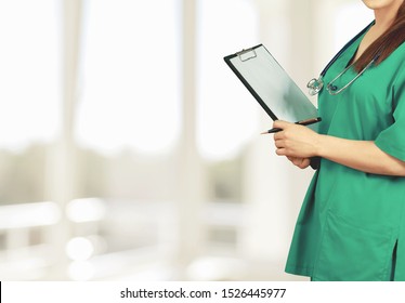 A Nurse Enrolled In A Bachelor Of Science In Nursing Degree Program, Holding A Binder In Her Arms And Wearing A Stethoscope.