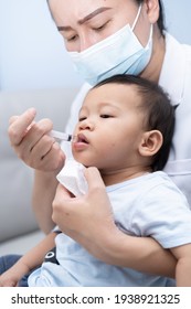 Nurse Is Entering Medicine Sick Child And Suffering Fever Heat By Using A Syringe. 