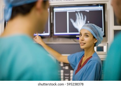 Nurse examining x-ray of hand