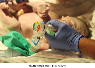 A Nurse Gives A Newborn Baby Oxygen In The Delivery Room