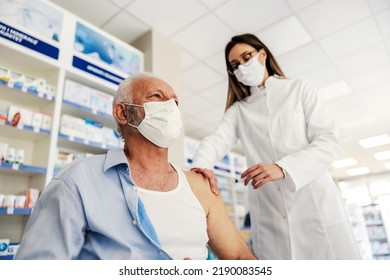 A nurse giving covid vaccine to an old man at pharmacy. - Powered by Shutterstock