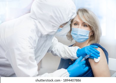 Nurse giving injection vaccine to elderly woman. Concept vaccination Covid-19 or coronavirus of senior people in houses, doctor visits home to provide assistance. - Powered by Shutterstock