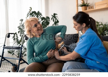 Nurse giving insulin injection to diabetic senior woman. Young healthcare worker using insulin injection pen for treatment of patient with type 1 diabetes. Senior patient satisfied with therapy.