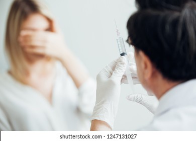 Nurse Hand With Syringe Needle And Woman Fear Of Injections Phobia Concept Against 