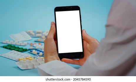 Nurse Hand In White Coat Use Phone With Chroma Key Display For Medication Information. Smarthphone With Mockup, Green Screen Medical. Pills Blisters.