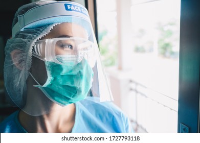 Nurse having tired from work while wearing PPE suit for protect coronavirus disease. PPE while protecting healthcare workers from exposure to the COVID-19 virus in healthcare settings. - Shutterstock ID 1727793118