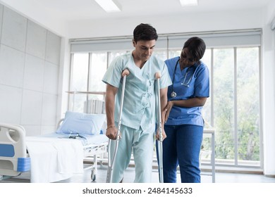 Nurse help patient man walk with walker careful at hospital. Woman assistant caring patient man walking with walker - Powered by Shutterstock