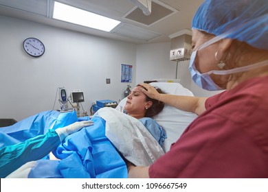 Nurse helping in baby delivery in clean hospital room - Powered by Shutterstock