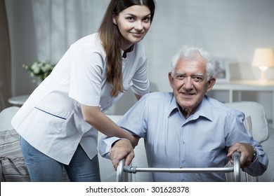Nurse helping disabled senior man with standing