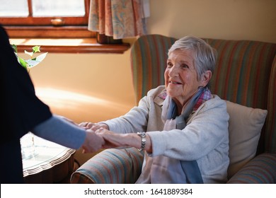 Nurse Helping Old Woman Holding Hands In Retirement Home