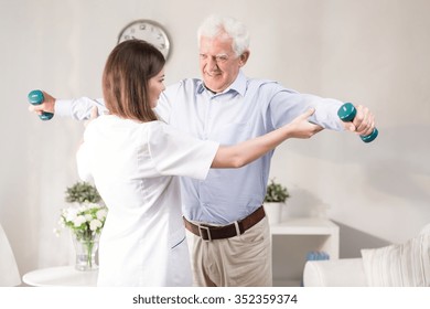 Nurse helping patient to exercise with dumbbels - Powered by Shutterstock