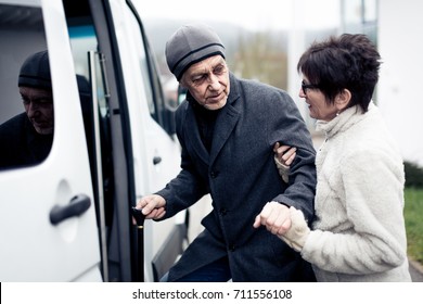 Nurse Helping Senior Man Enter A Van