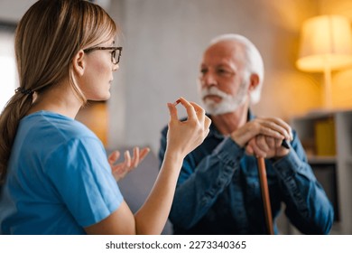 Nurse Helping Senior Man To Organize Medication On Home Visit. Nurse giving senior man prescription drugs. Senior male patient consult with physician nurse at nursing home. - Powered by Shutterstock