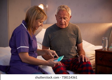 Nurse Helping Senior Man To Organize Medication On Home Visit