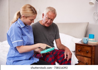 Nurse Helping Senior Man To Organize Medication On Home Visit