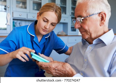 Nurse Helping Senior Man To Organize Medication On Home Visit