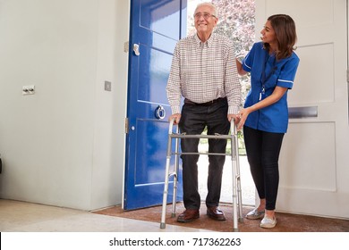 Nurse Helping Senior Man Using A Walking Frame At Home