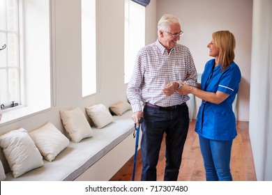 Nurse Helping Senior Man Walk Using A Walking Stick