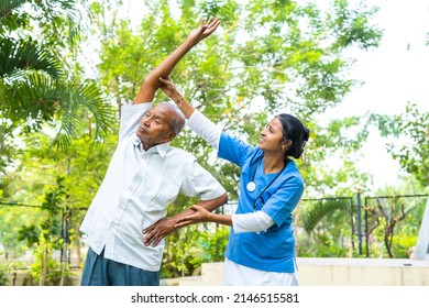 Nurse helping senior old man helping to do exercise at nursing home - concept of caretaker, well-being and rehabilitation