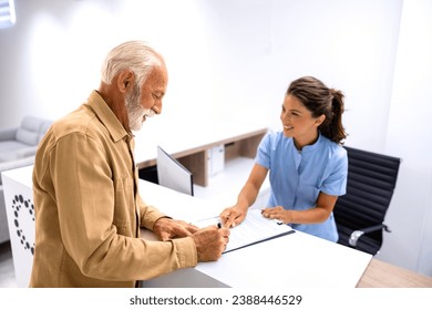 Nurse helping senior patient to fill out medical questionnaire before visiting the doctor in hospital. - Powered by Shutterstock