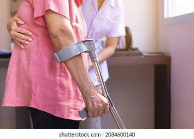 Nurse Helping Senior Woman Hand Using Crutches Trying To Walk,Care Nursing Home Concept