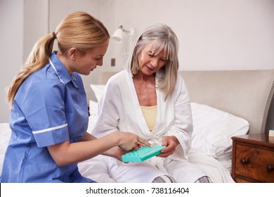 Nurse Helping Senior Woman To Organize Medication On Home Visit