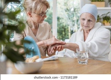 Nurse Helping Sick Elderly Woman With Cancer During Treatment At Home