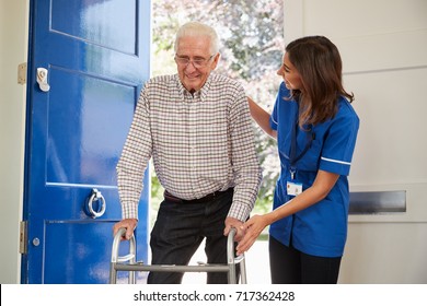 Nurse Helps Senior Man Using Walking Frame At Home, Close Up