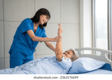 Nurse helps senior woman do physical therapy at the hospital bed. Healthcare, Retirement, Volunteer, Caregiver and Lifestyle concept. - Powered by Shutterstock