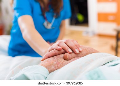 Nurse holding the hand of an elderly woman, showing sympathy and kindness.