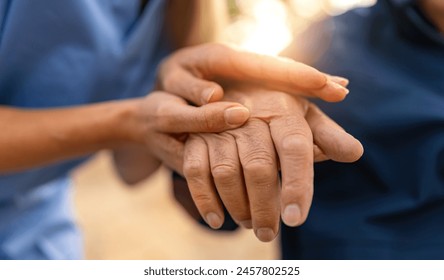 Nurse holding hand of senior man in wheel chair - Powered by Shutterstock