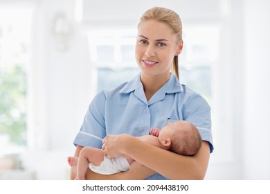 Nurse holding newborn baby in hospital