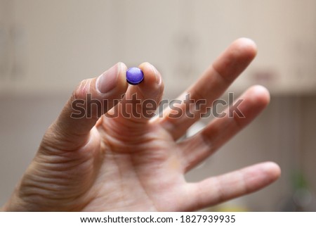 The nurse holds the plaque indication tablets in a pinch