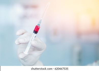 Nurse Holds A Syringe With A Universal Vaccine Against The Zik Virus, Epidemic Of Ebola, Poultry And Swine Flu, Malaria, Hepatitis. The Concept Of Saving From Disease.