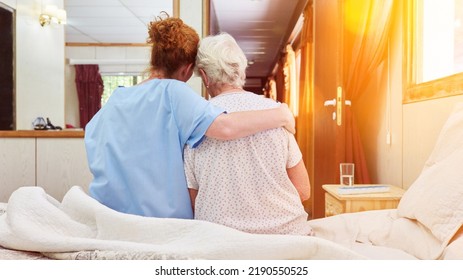 Nurse in hospice hugs elderly woman on bed for comfort while grieving - Shutterstock ID 2190550525