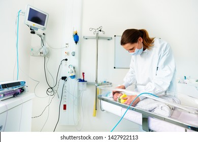 Nurse In ICU Examining Premature Born Baby